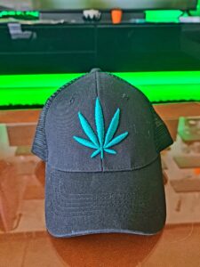 Czarna czapka z zielonym znakiem konopi